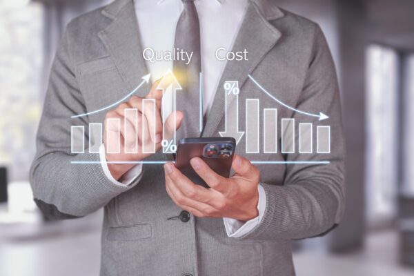 Quality and Cost Analysis. Businessman using smartphone with quality improvement and cost reduction.